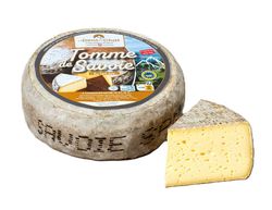 KI generiert: Das Bild zeigt ein Stück weißen Käse, das auf einer schwarzen Schieferplatte in vier Portionen geschnitten ist, daneben ist eine verpackte, identische Käserolle abgebildet.