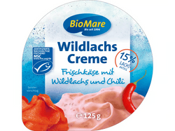 KI generiert: Auf dem Bild befindet sich eine durchsichtige Plastikverpackung mit Ziegenfrischkäse, der mit Kräutern und rosa Pfefferkörnern verfeinert ist. Das Etikett trägt die Aufschrift "ZiegenFRISCHKÄSE" der Marke Biovela.