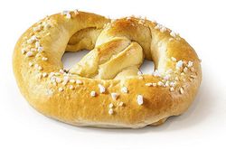 KI generiert: Das Bild zeigt ein rundes Brot, das mit Sesamkörnern bestreut ist und zur Hälfte abgeschnitten wurde. Es liegt auf einem neutralen Hintergrund.