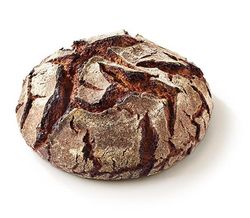 KI generiert: Das Bild zeigt ein rundes, rustikales Vollkornbrot mit einer knusprigen Kruste. Der Hauptinhalt ist das Brot, das auf einem hellen Hintergrund präsentiert wird.