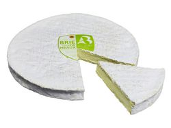 KI generiert: Das Bild zeigt ein Stück weißen Käse, das auf einer schwarzen Schieferplatte in vier Portionen geschnitten ist, daneben ist eine verpackte, identische Käserolle abgebildet.