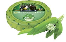 KI generiert: Das Bild zeigt ein Stück weißen Käse, das auf einer schwarzen Schieferplatte in vier Portionen geschnitten ist, daneben ist eine verpackte, identische Käserolle abgebildet.