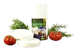 KI generiert: Das Bild zeigt ein Stück weißen Käse, das auf einer schwarzen Schieferplatte in vier Portionen geschnitten ist, daneben ist eine verpackte, identische Käserolle abgebildet.