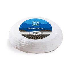 KI generiert: Das Bild zeigt ein Stück weißen Käse, das auf einer schwarzen Schieferplatte in vier Portionen geschnitten ist, daneben ist eine verpackte, identische Käserolle abgebildet.