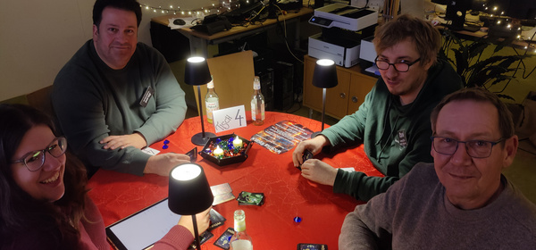 KI generiert: Vier Personen spielen gemeinsam ein Kartenspiel an einem Tisch. Der Tisch trägt die Aufschrift "Tisch 4".