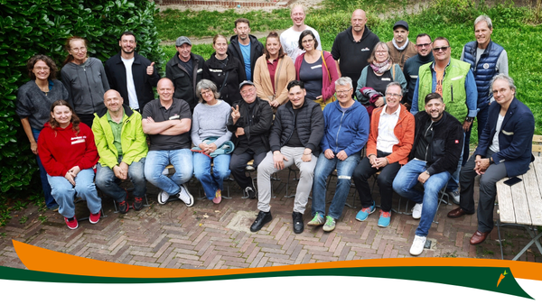 KI generiert: Gruppenfoto von Personen in Outdoor-Kleidung vor grünem Hintergrund.