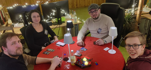 KI generiert: Vier Personen spielen ein Kartenspiel an einem Tisch mit Getränken und Snacks.