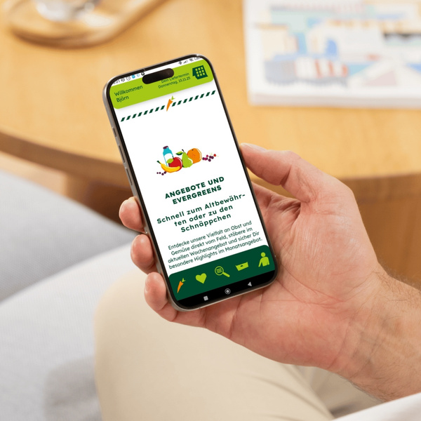 KI generiert: Eine Hand hält ein Smartphone mit einer Lebensmittel-App und Text: "ANGEBOTE UND EVERGREENS."