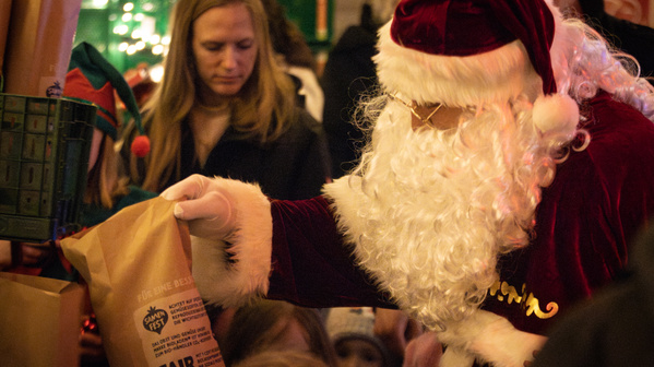 KI generiert: Weihnachtsmann verteilt Geschenke an Kinder. Ein Sack trägt den Text "FAIR". 