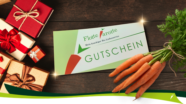 KI generiert: Das Bild zeigt einen Gutschein für einen Bio-Lieferservice namens "Flotte Karotte" neben einer Ansammlung frischer Karotten und Geschenkboxen. Die Szene wirkt festlich und einladend.