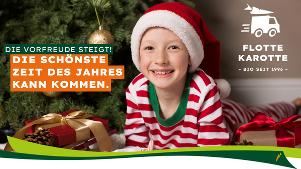 KI generiert: Ein Kind in Weihnachtskleidung neben Geschenken; Text: "DIE SCHÖNSTE ZEIT DES JAHRES KANN KOMMEN."