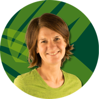 KI generiert: Eine lächelnde Person vor einem grün gemusterten Hintergrund.