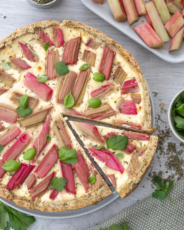 KI generiert: Eine herzhafte Tarte mit Rhabarber, garniert mit frischen Kräutern.